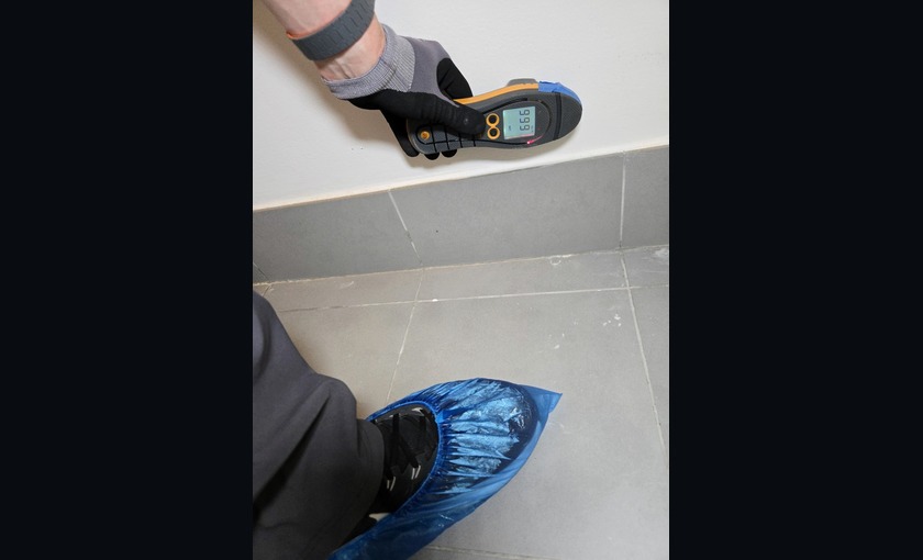 Apex professional using shoe protection while taking a moisture reading